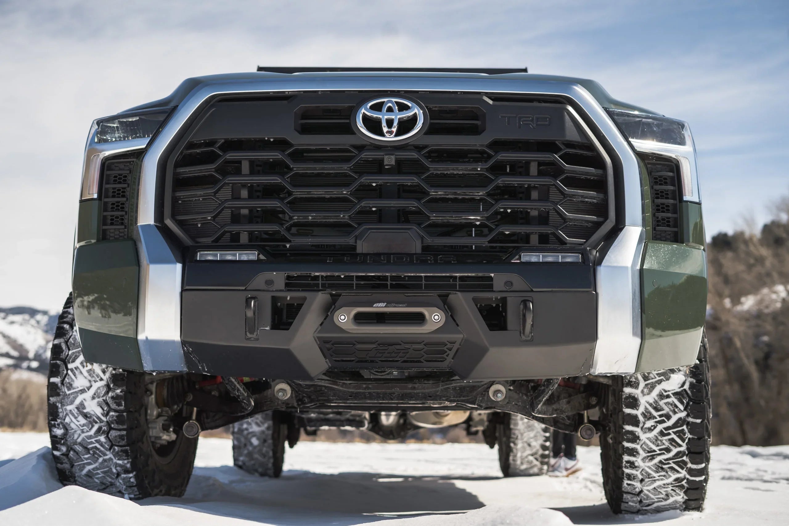 Front view of Toyota Tundra TRD with off-road tires and winch on snowy terrain