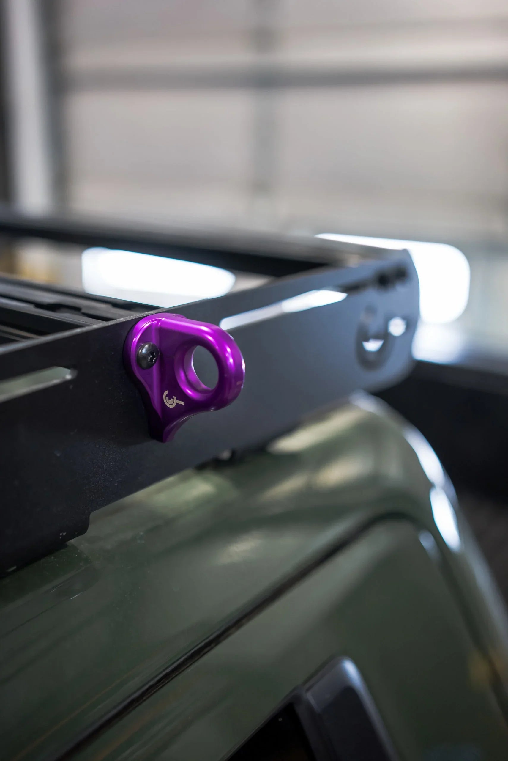 Purple utility hook mounted on a black roof rack for overlanding vehicles