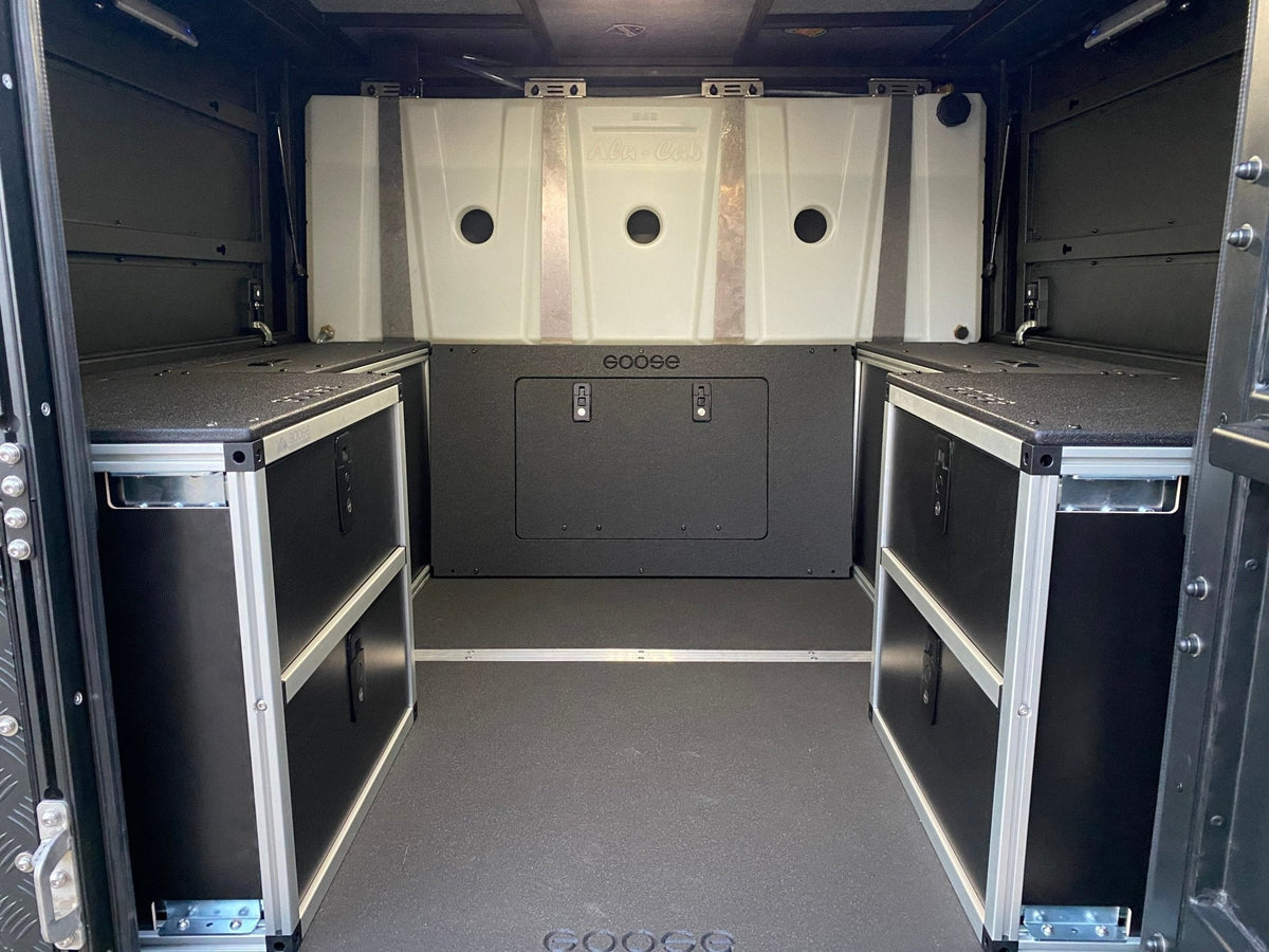 Goose Gear Alu-Cab canopy camper lower bulkhead panel for a Toyota Tacoma, drawers and white water tanks at front