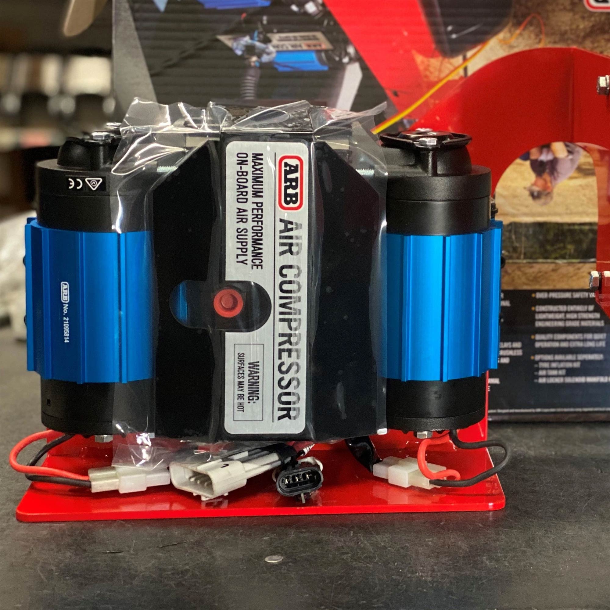 ARB twin air compressor with blue cylinders and red mounting bracket for off-road vehicles