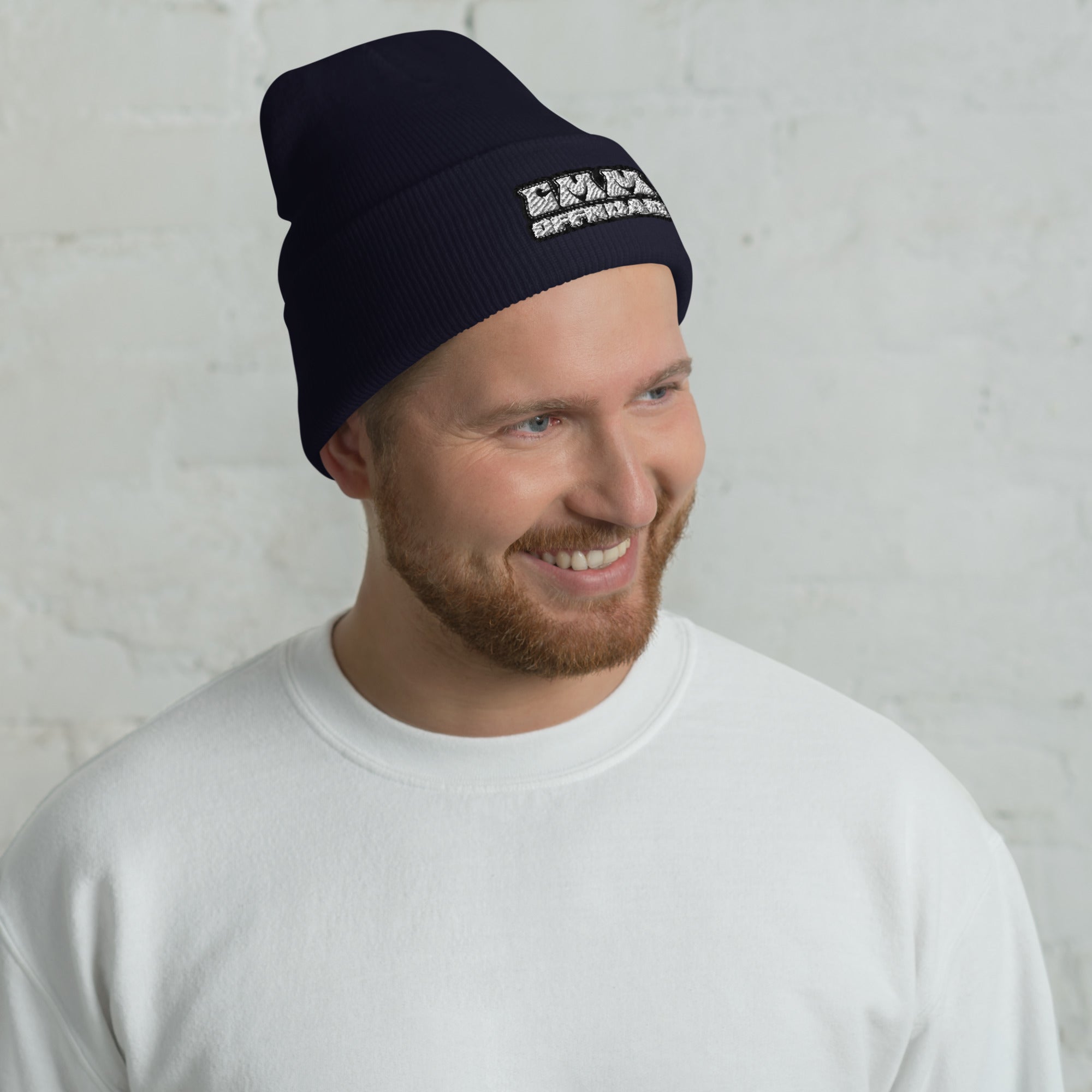 Man wearing navy cuffed beanie with embroidered patch, adventure outdoor style