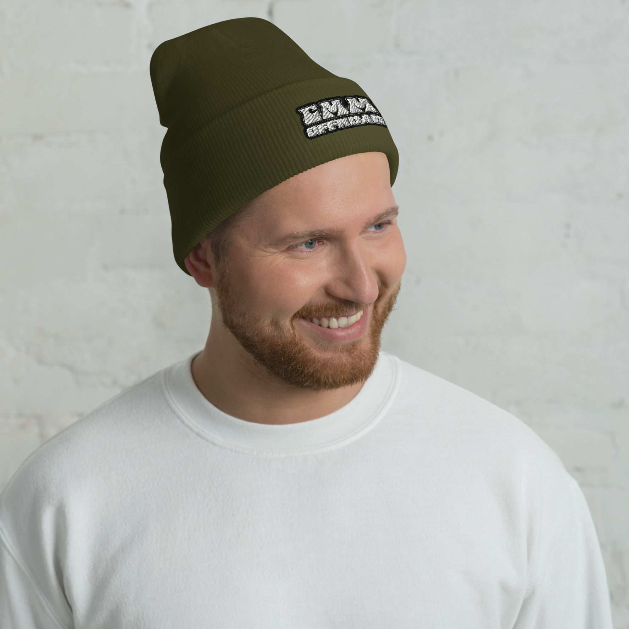 Man wearing olive green cuffed beanie with embroidered patch, casual winter hat