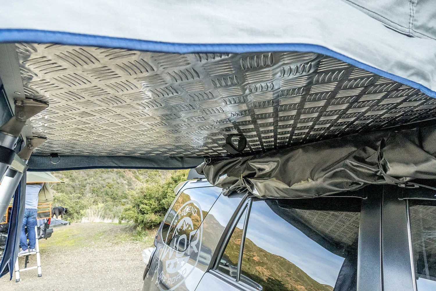 Diamond plate metal roof panel on vehicle awning for overlanding and camping