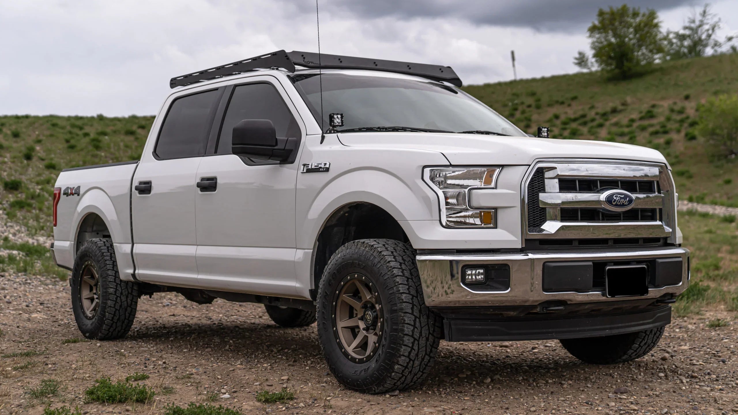 Ford F-150 MLT with off-road roof rack on rugged terrain, overlanding gear focus