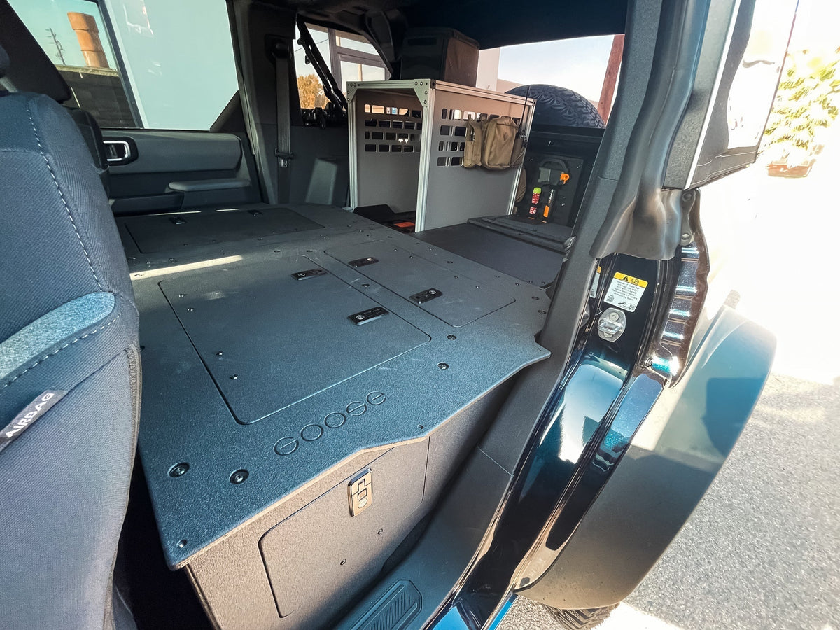 Goose Gear second row seat delete plate system in a 4-door Ford Bronco, flat deck and cargo boxes behind the front seats