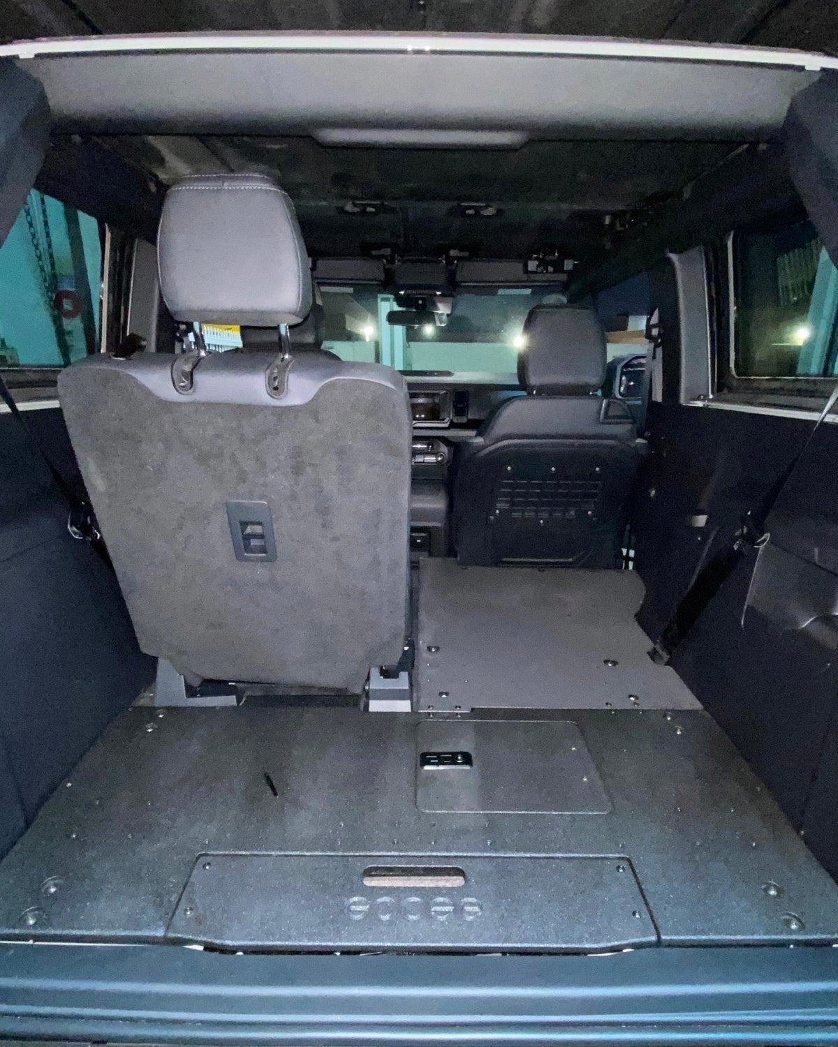 Goose Gear second row seat delete plate system in a 2 door Ford Bronco with the rear seat folded and a flat black floor