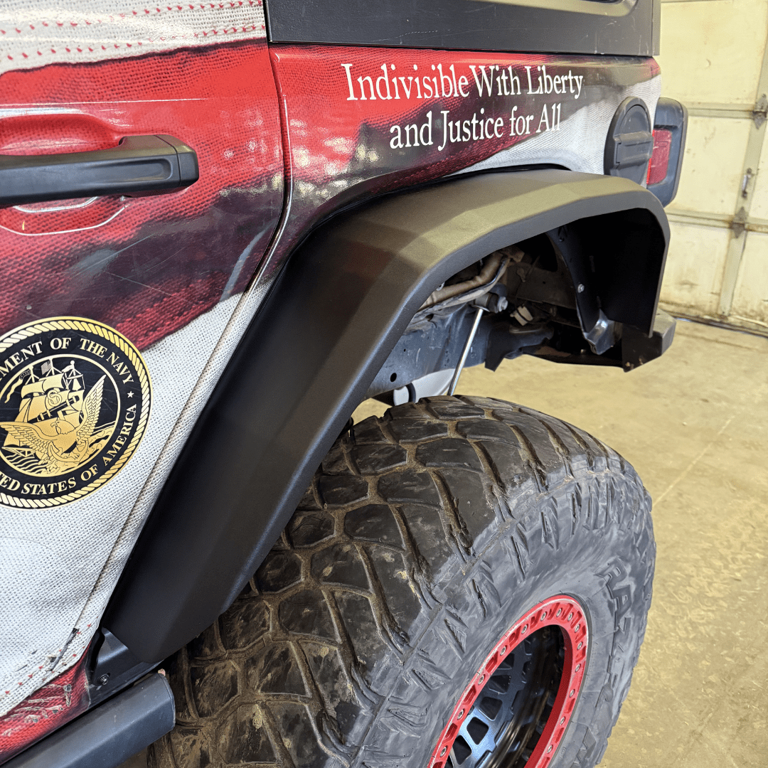 Jeep Wrangler rear fender flare with off-road tire and patriotic vehicle wrap