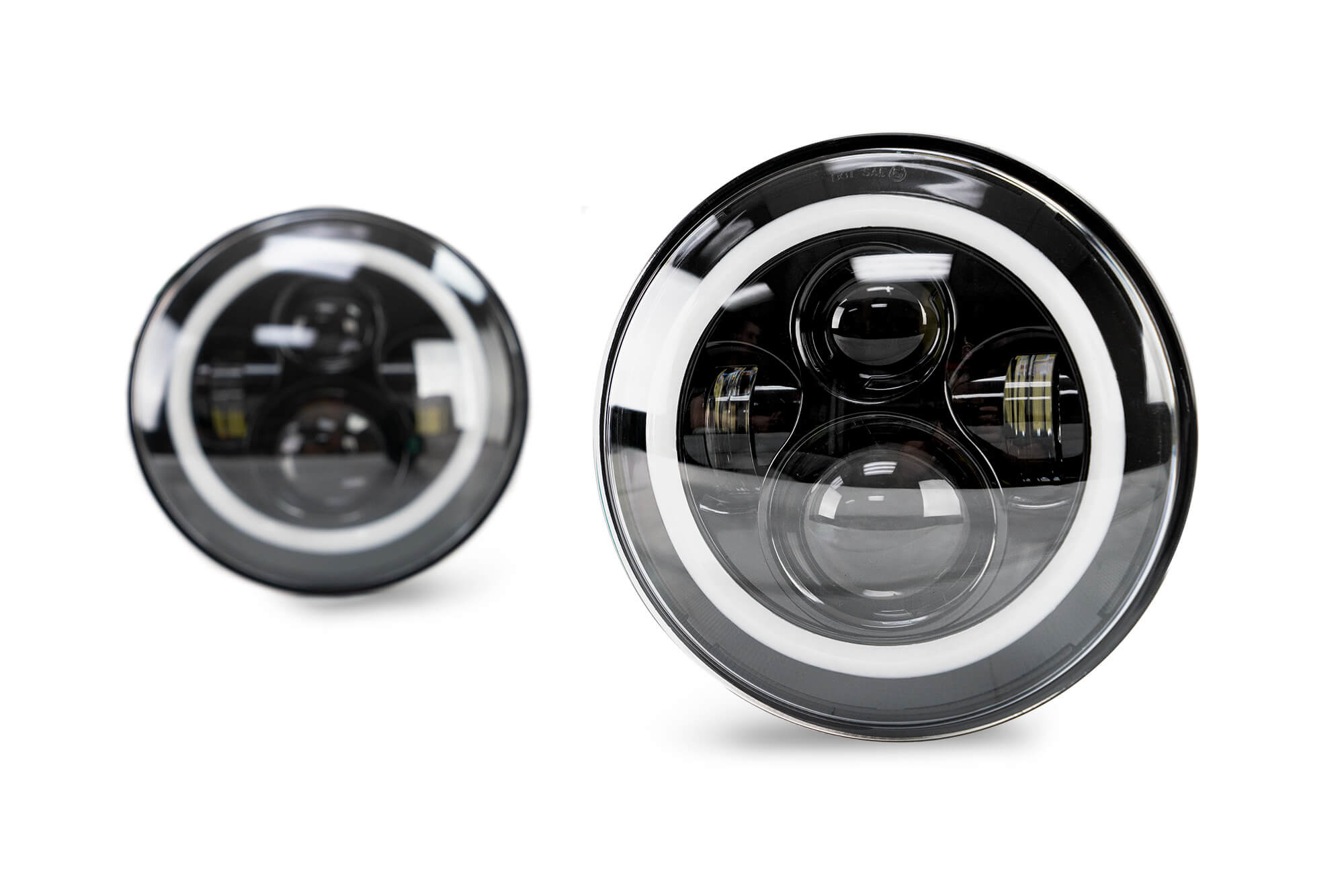 Pair of Jeep Wrangler LED halo headlights with circular DRL rings on white background