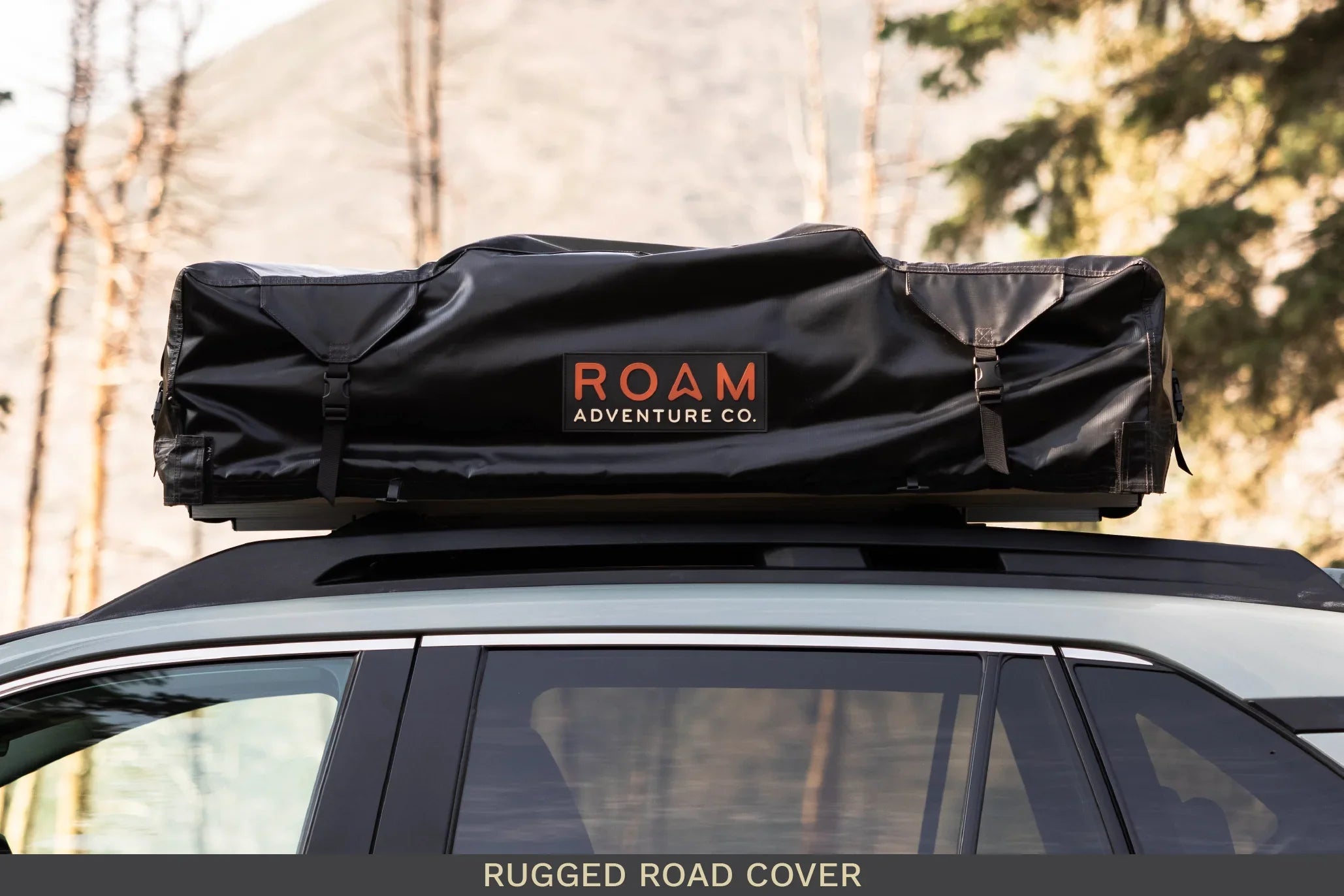 Black rooftop cargo bag labeled ROAM Adventure Co. on SUV for overlanding and camping