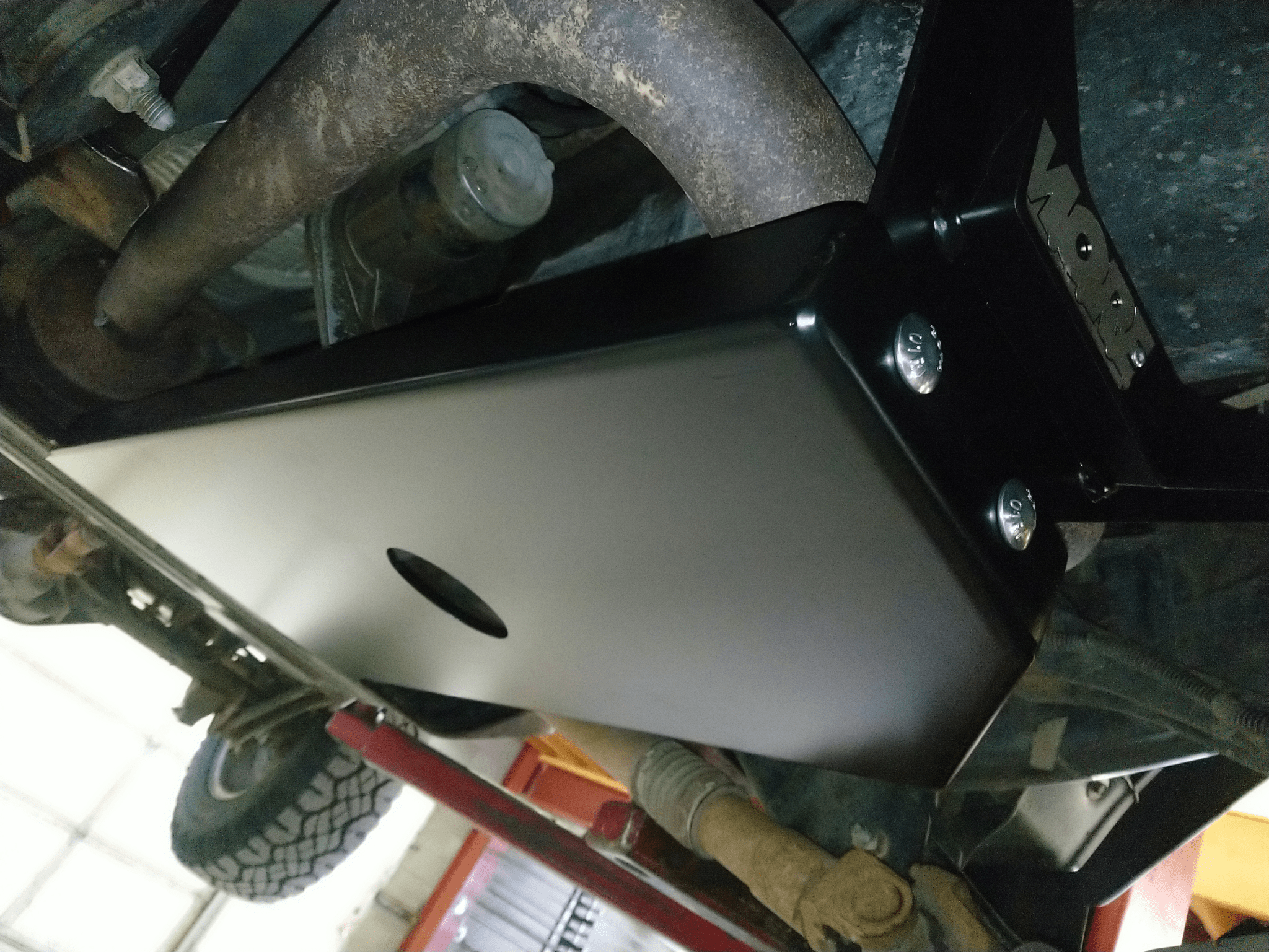 Black steel skid plate installed under Jeep Wrangler TJ protecting oil pan and transmission