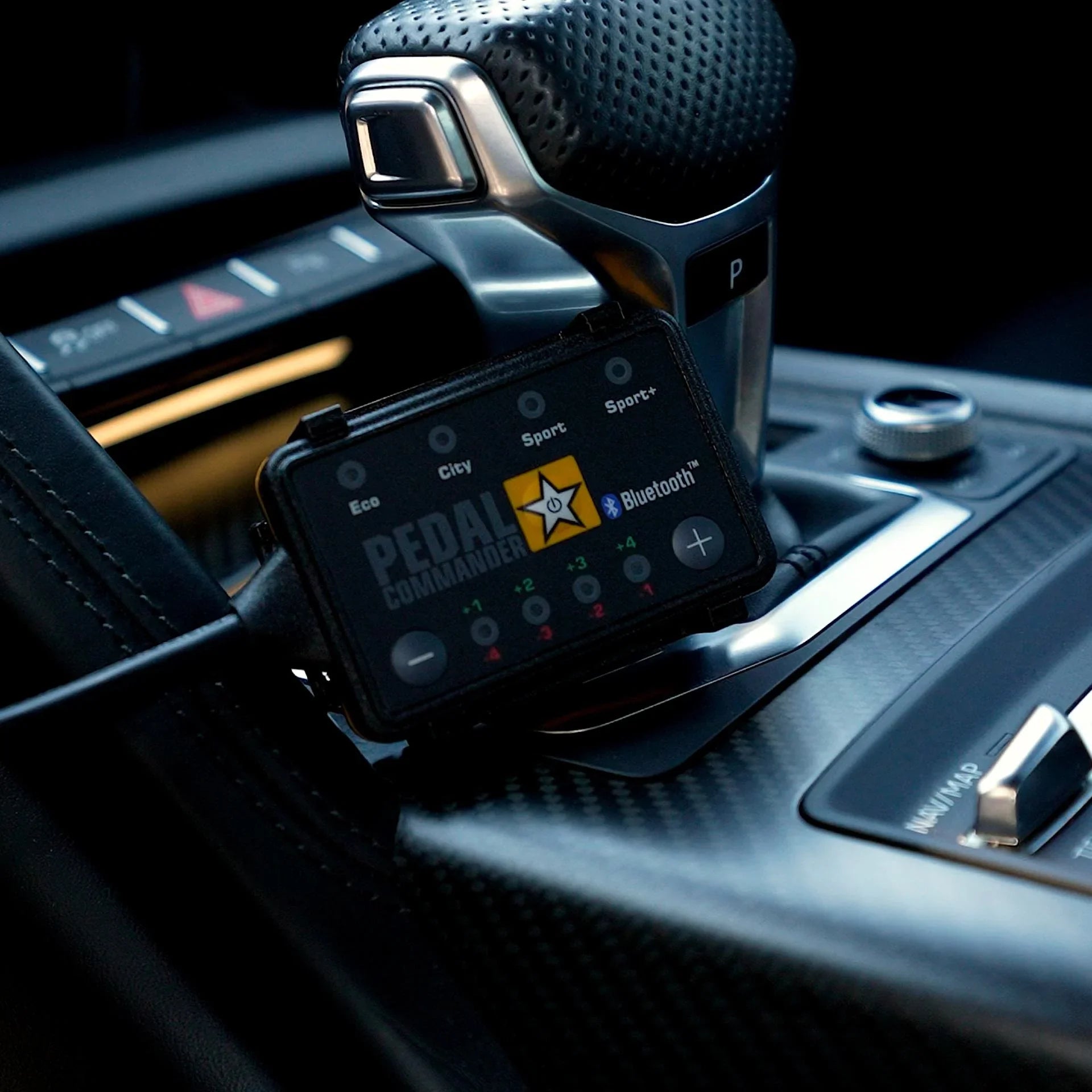 Pedal Commander throttle response controller installed near car gear shifter in vehicle interior