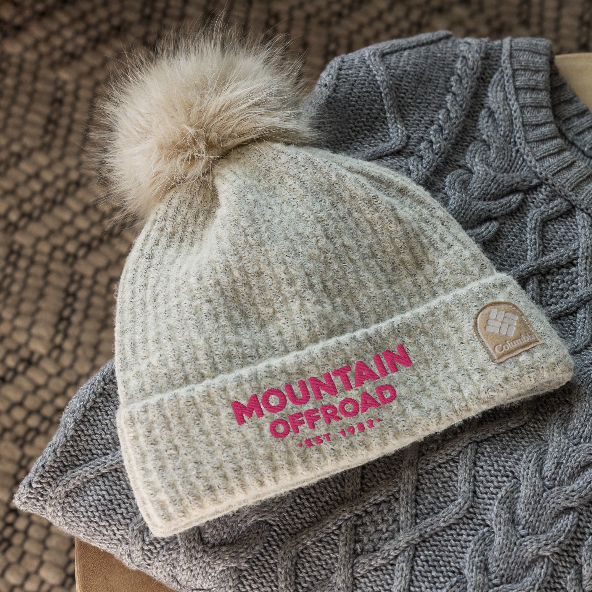 Cream pom pom beanie with 'Mountain Offroad' text, knit texture, outdoor winter style