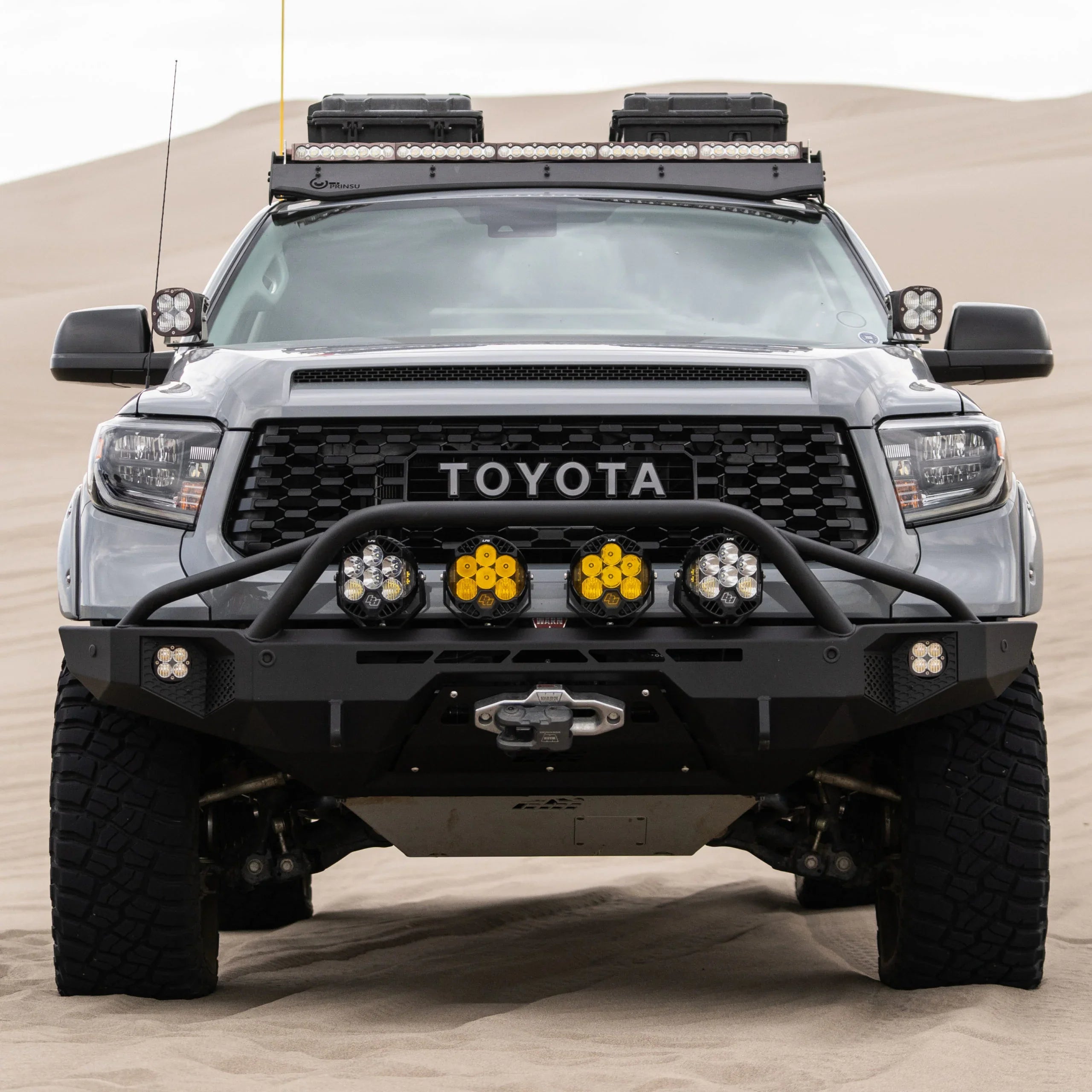 Toyota truck with off-road accessories and LED lights on sand dunes, front view
