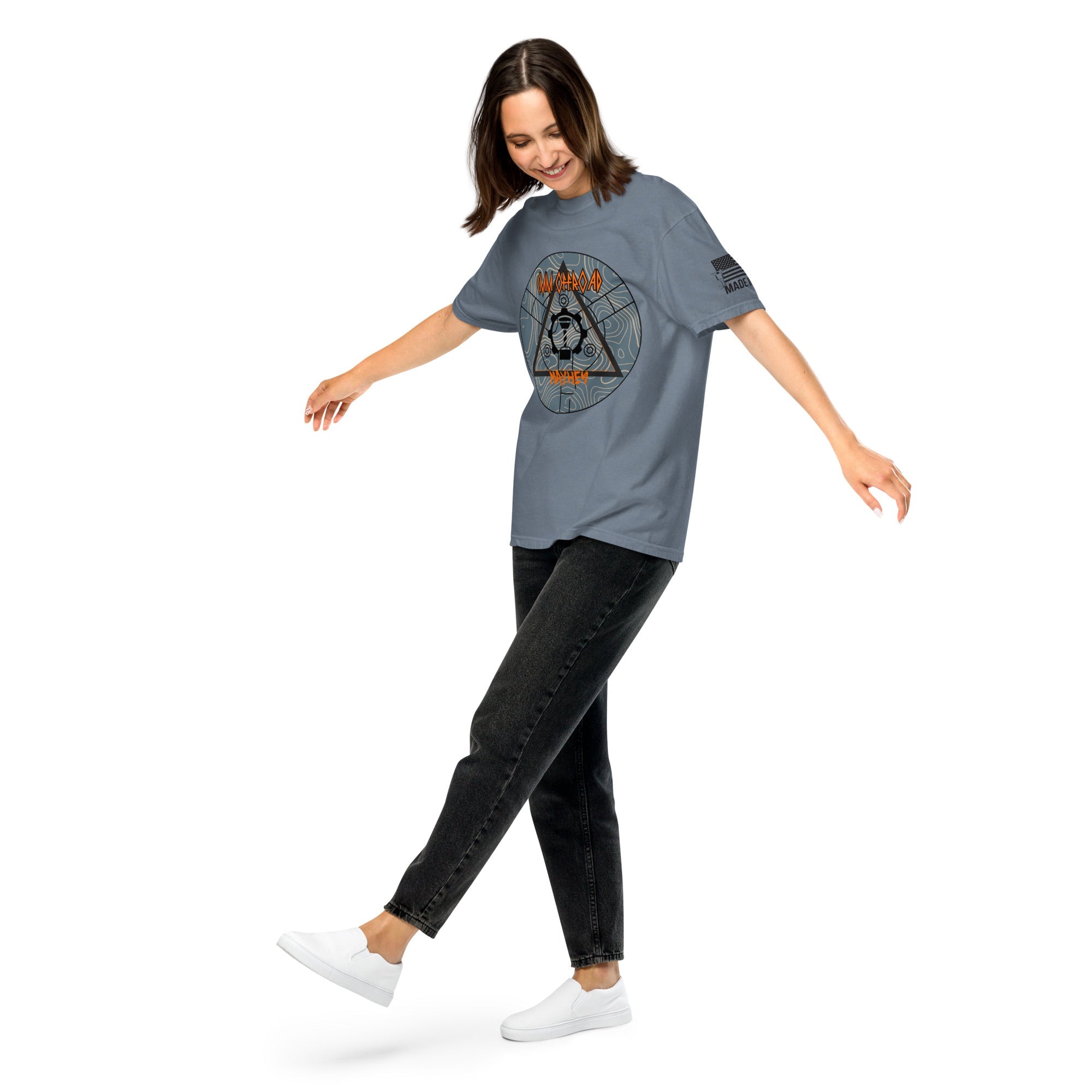 Unisex blue heavyweight t-shirt with adventure-themed graphic, worn by woman in casual pose