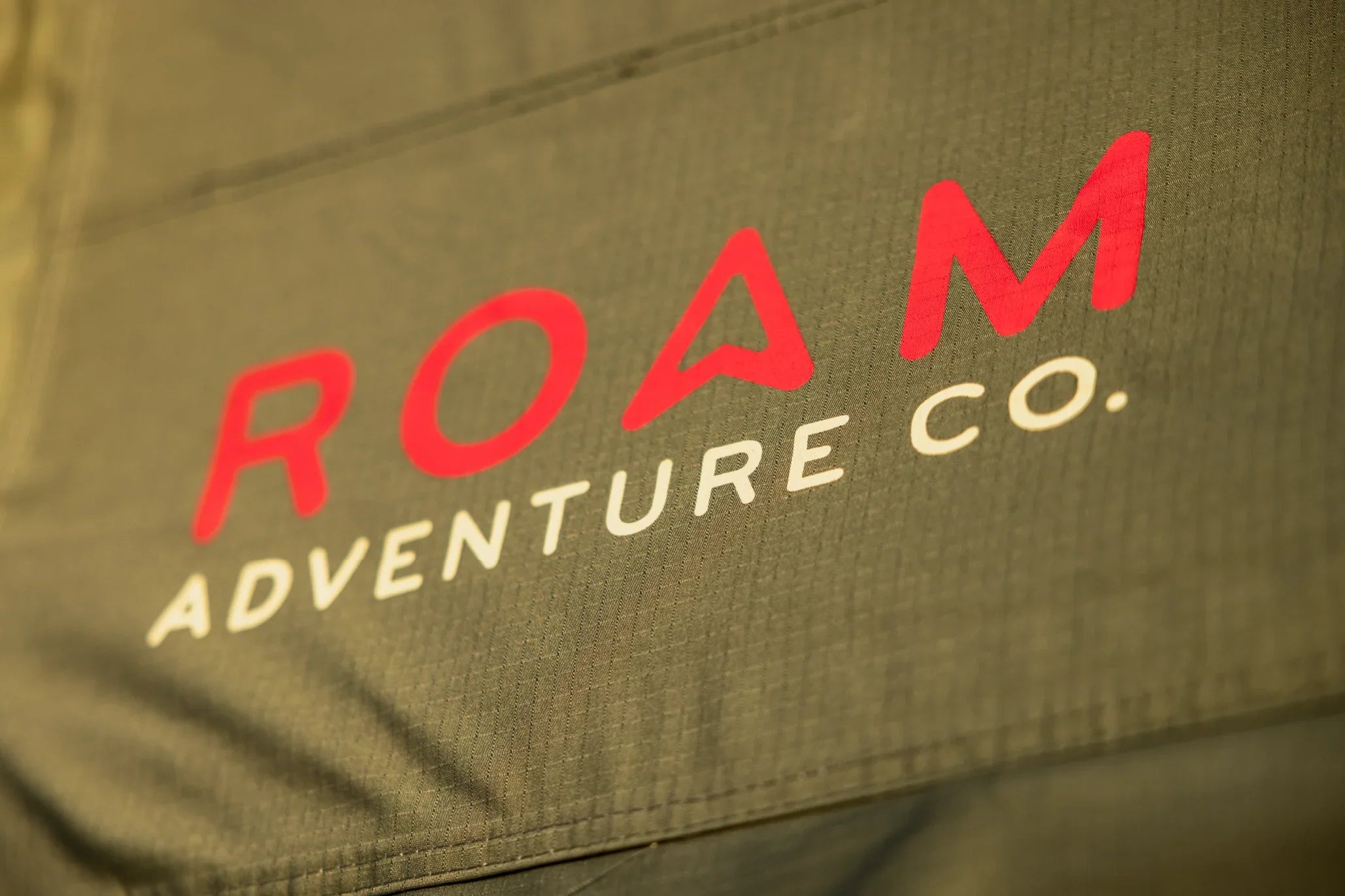 ROAM Adventure Co. logo on rugged fabric, outdoor camping gear detail
