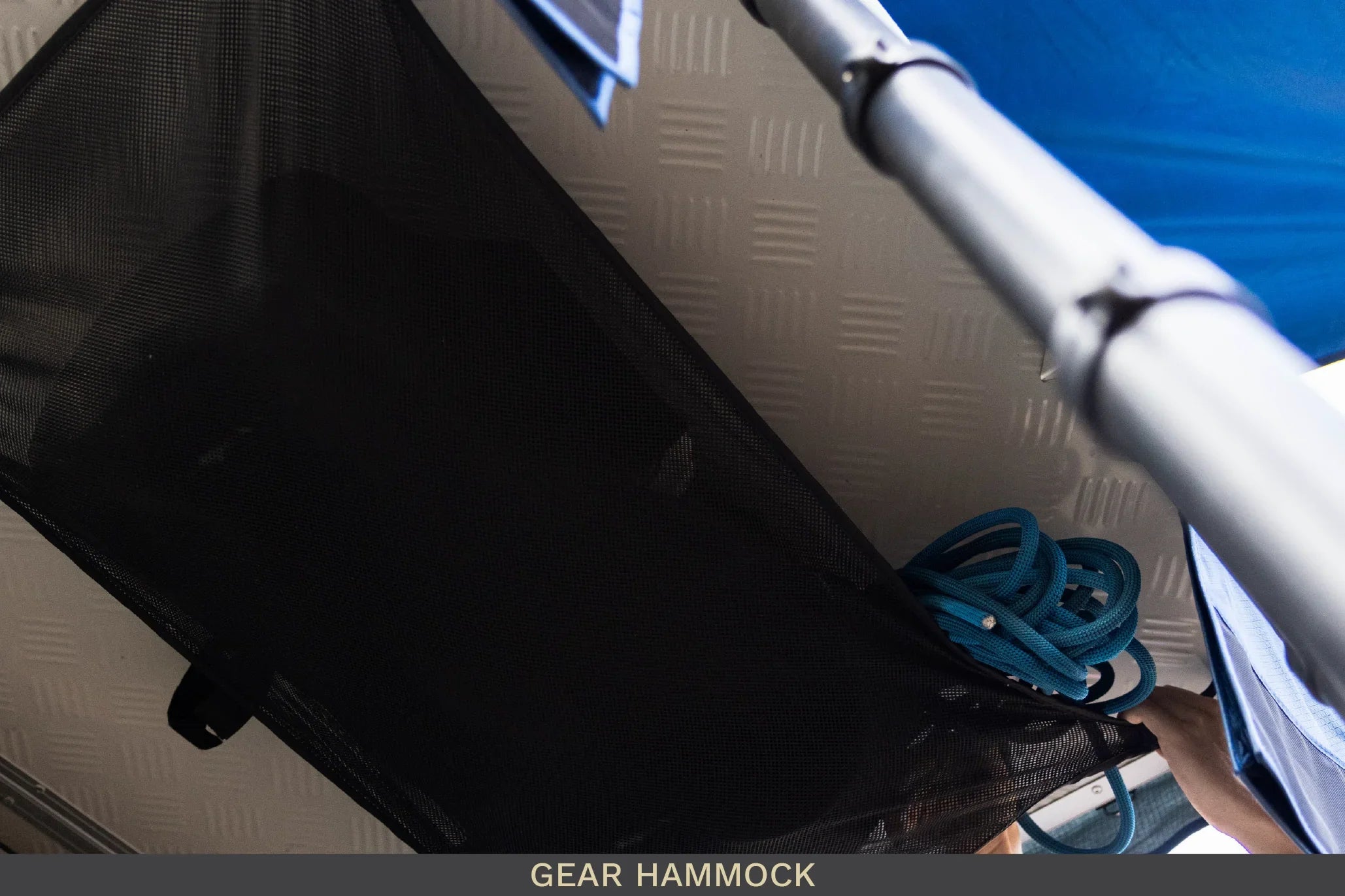 Mesh gear hammock holding blue rope in overland vehicle storage setup