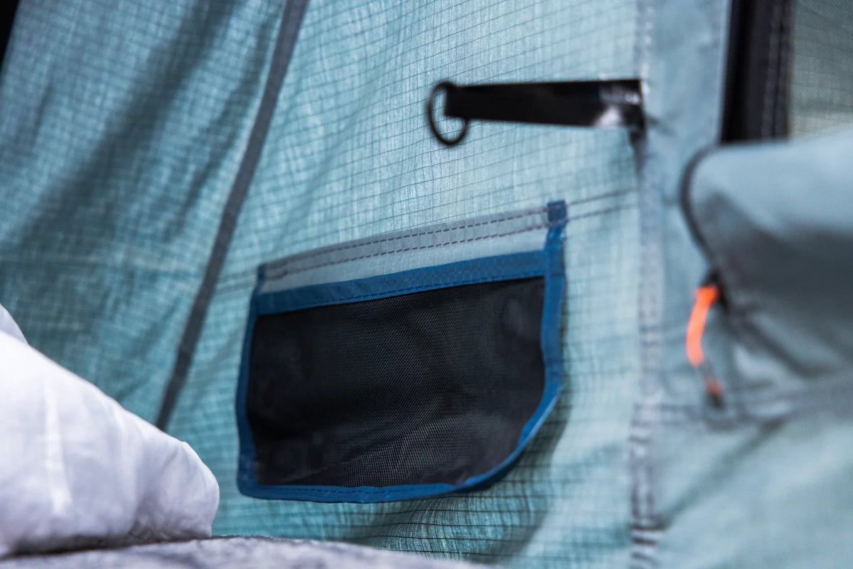 Close-up of mesh storage pocket inside outdoor camping tent with durable stitching
