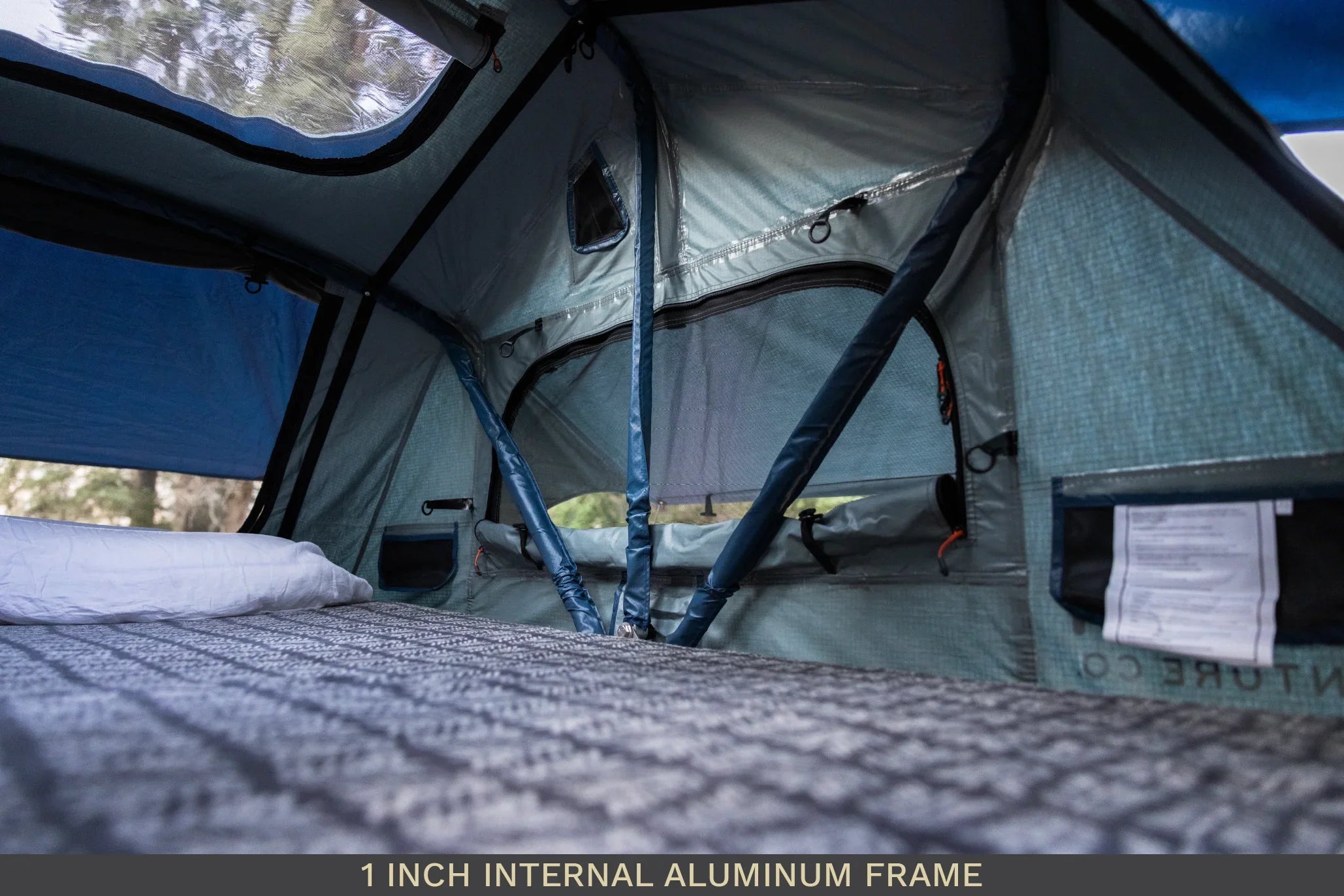 Interior view of rooftop tent with aluminum frame, insulated fabric, and mesh windows