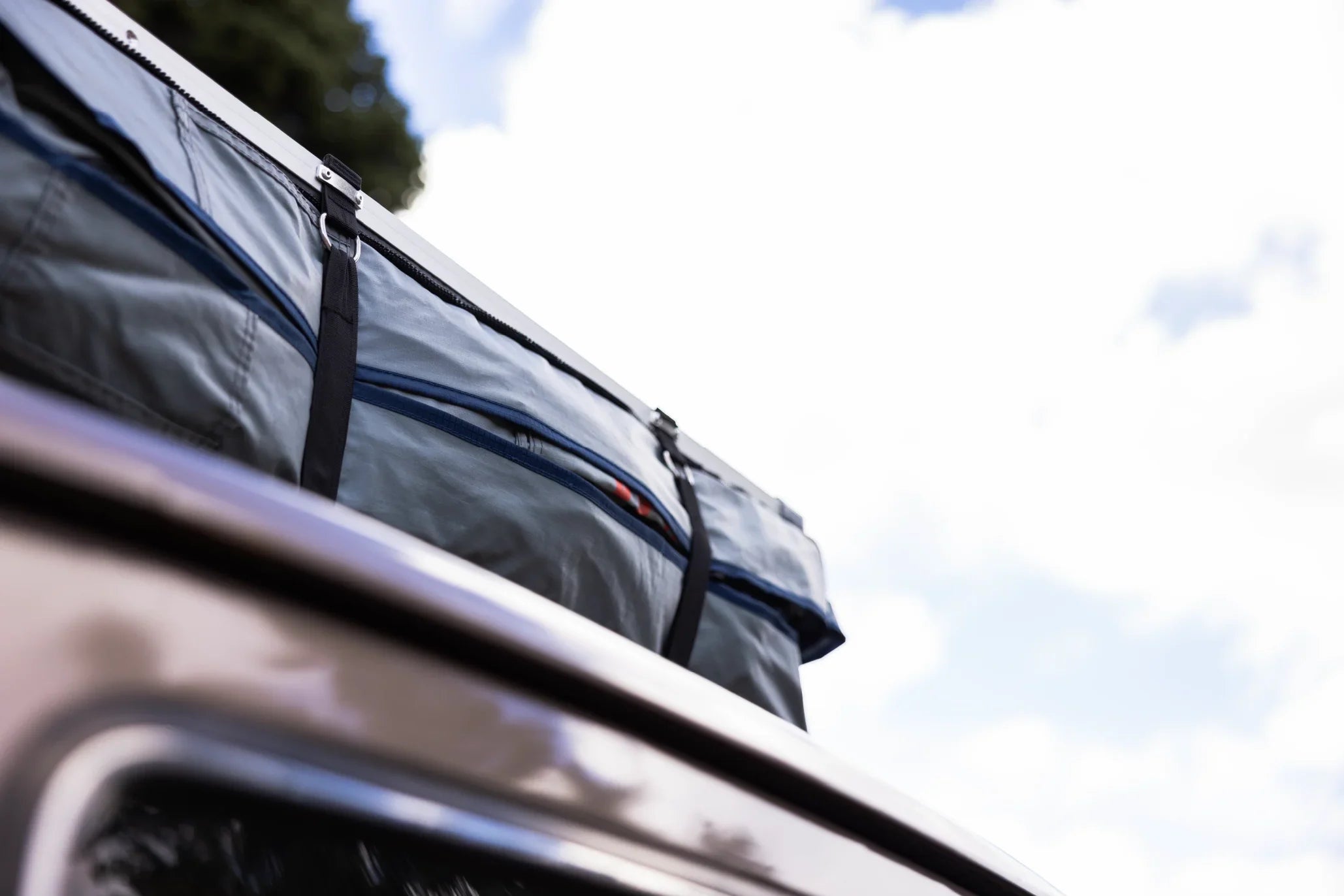 Close-up of rooftop tent secured to vehicle, ideal for overlanding and expedition camping.